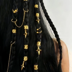 Detailed view of gold moon and star hair rings worn on black braids for DIY styling