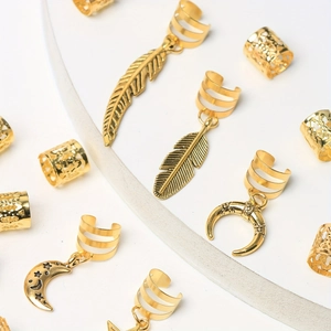 Détail de bijoux de cheveux dorés avec pendentifs lune, étoile et plume en alliage poli