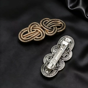 Vintage knot alloy spring hair clips in bronze and silver on black silk background