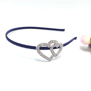 Detail of blue satin headband with two intertwined sparkling rhinestone heart motifs