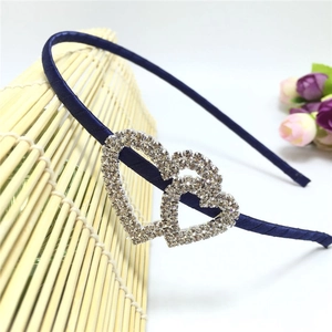 Detailed close-up of navy satin headband with shimmering rhinestone double heart decor