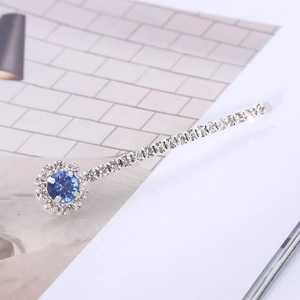Elegante zilveren haarspeld met een grote blauwe edelsteen en glinsterende strassteentjes