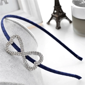 Detail of navy blue ribbon headband featuring a sparkling infinity rhinestone ornament