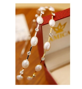 Detailed view of gold and silver metal headbands with oval pearls and sparkling rhinestones