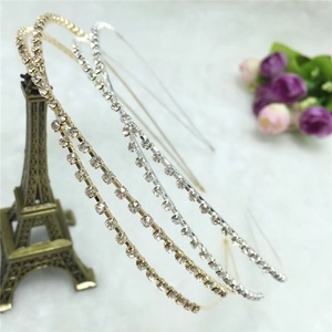 Détail de deux serre-têtes fins en or et argent sertis de strass scintillants