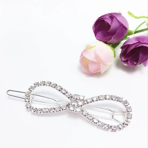 Detailed view of a silver bow hair clip with sparkling rhinestones on a white background