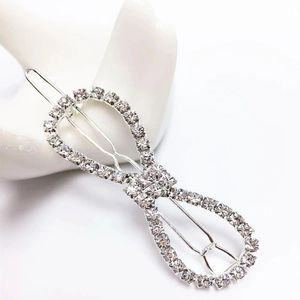 Detailed close-up of a silver bow hair clip with sparkling rhinestones on ceramic