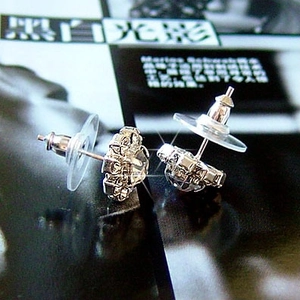 Vue détaillée des boucles d'oreilles fleurs argentées avec zircons et fermoirs en plastique