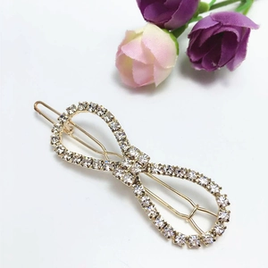 Detailed macro view of an alloy hair clip featuring crossed lines and sparkling rhinestones
