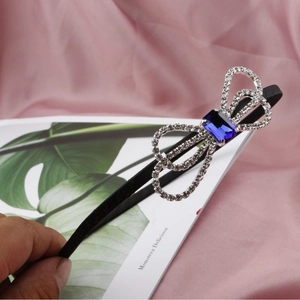 Elegant black headband with rhinestone bow and deep blue square crystal centerpiece