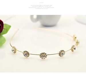 Détail d'un serre-tête doré orné de sept fleurs scintillantes en strass cristallins