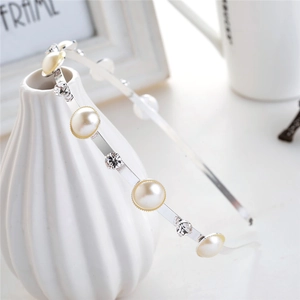Elegant thin silver headband with pearls and rhinestones on a decorative ceramic vase