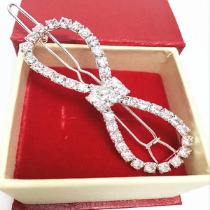 Close-up of sparkling rhinestone bow hair clip on red velvet lining in a jewelry box