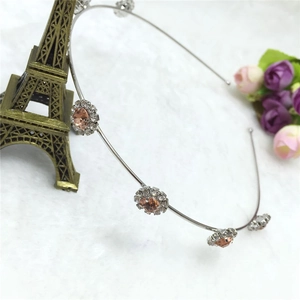 Détail du serre-tête argenté avec cinq fleurs en cristaux de couleur champagne et strass