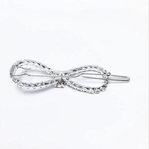 Detail view of infinity-shaped hair clip with clear rhinestones on silver metal base