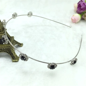 Détail du serre-tête argenté avec cinq fleurs de soleil en cristaux noirs et strass blancs