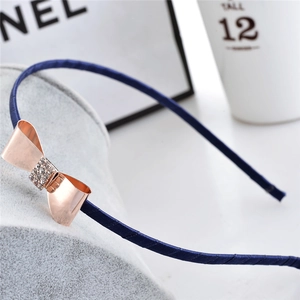 Serre-tête bleu marine élégant avec nœud en strass or rose sur fond chic