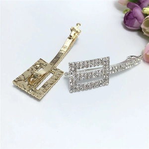 Macro shot of gold and silver rectangle hair clips with sparkling crystal rhinestones