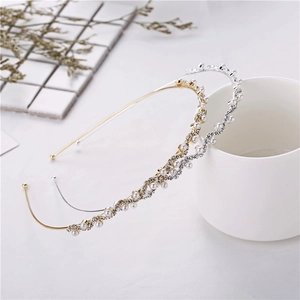 Detail of wavy gold and silver headbands with pearls and rhinestones on a white cup
