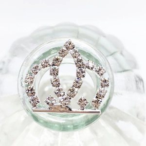 Macro detail of silver crown hair pin accessory with sparkling rhinestones