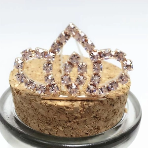 Close-up of rose gold crown hair pin with sparkling purple rhinestones and intricate design