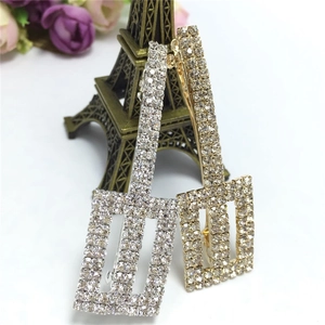 Detail shot of gold and silver rectangle BB hair clips encrusted with crystal rhinestones