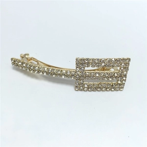 Detailed view of rectangle gold hair clip with sparkling rhinestones and crystal inlay