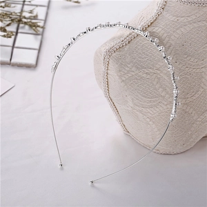 Detailed close-up of slim silver headband with pearls and rhinestones on display
