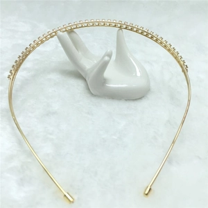 Detail of double-row rhinestone headband in gold-plated alloy on a soft fur background