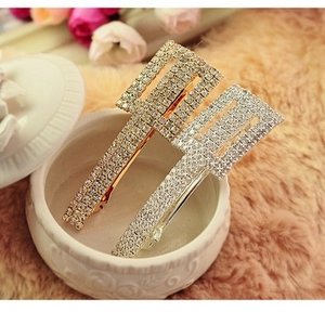 Sparkling rhinestone rectangular hair clips in gold and silver set on white porcelain