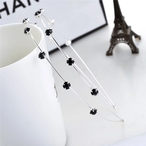 Detailed view of silver metal headband with black faceted rhinestones on a ceramic mug