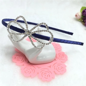 Serre-tête élégant en satin bleu marine avec nœud en strass sur une surface douce