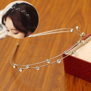Detail of double-layer silver metal headband with sparkling crystals on wood background