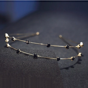 Detail view of double-layered gold headband with sparkling round black crystals