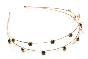 Detail of double-layer gold metal headband with black crystals in a claw-set design