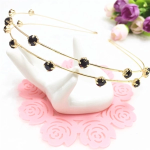 Double-row gold headband with black rhinestones shown on a model display