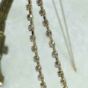 Détail macro de glands en strass à double couche sur base métallique dorée pour cheveux