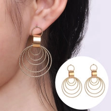 Detail of gold layered concentric circle drop earrings with stylish minimalist design