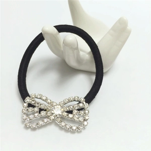 Elegant black elastic hair tie with sparkling rhinestone bow on a white hand display