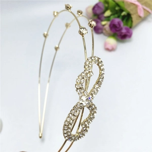 Detailed macro view of a golden double-loop headband featuring infinity rhinestone accents