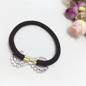 Macro shot of black elastic hair tie with a sparkling infinity-shaped rhinestone metal piece