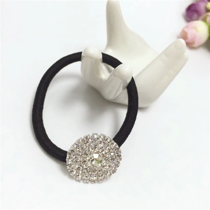 Detail of high-elastic black hair tie featuring a sparkling rhinestone-encrusted round charm