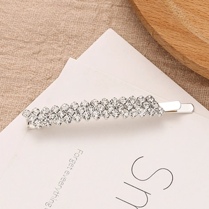 Barrette argentée ornée de quatre rangées de cristaux brillants sur carte blanche