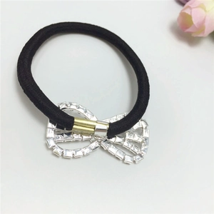 Close-up of black elastic hair tie featuring a sparkling rhinestone bow with silver base