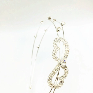 Detailed close-up of a silver headband featuring sparkling rhinestones and an infinity motif
