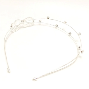 Close-up of double-layered silver headband with rhinestones and bow detail
