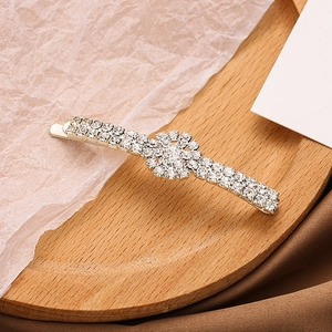 Detailed close-up of a silver sunflower hair clip with sparkling rhinestones in a tray