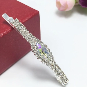 Close-up of sparkling rhinestone hair clip with holographic crystal on a red gift box