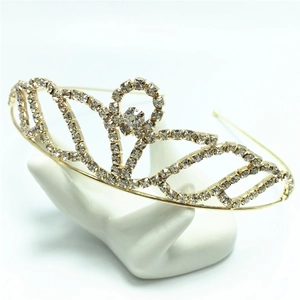 Detail view of a gold-toned bridal tiara with sparkling rhinestones on a hand stand
