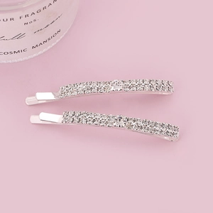 Elegant silver-tone hair clips set with sparkling double-row crystals on a pink surface